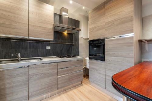 a kitchen with wooden cabinets and a sink and a stove at Appartamento luminoso in Mestre by Bricola Apartments in Venice