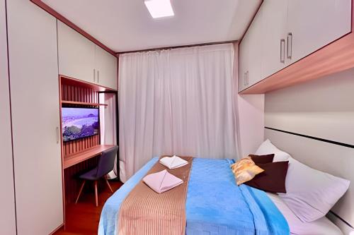 a bedroom with a bed with a desk and a television at LiNDO Studio, com garagem e Ar Condicionado in Curitiba