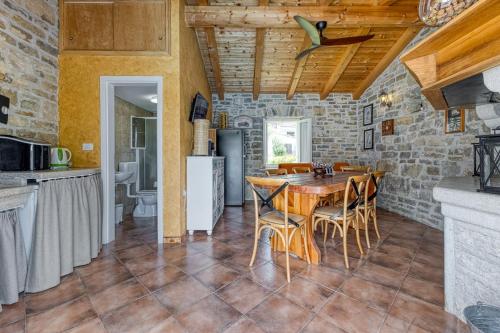 a kitchen and dining room with a table and chairs at Casa Levade in Livade