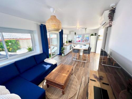 un salon avec un canapé bleu et une table dans l'établissement Luxueux appartement à 50m du front de mer, à Canet