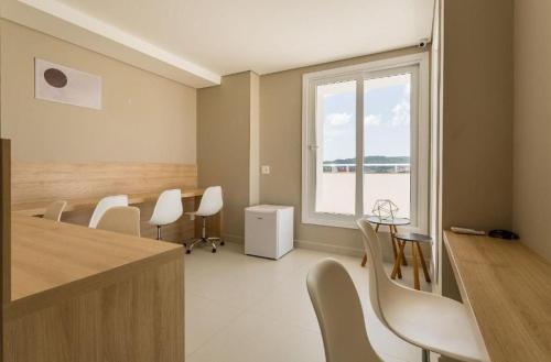 a room with chairs and a table and a window at SPA - Studios incríveis em Floripa-SC in Florianópolis