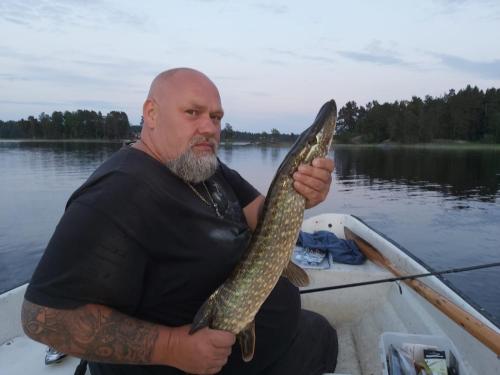 a man holding a fish in a boat at Naturparadies und Angeloase Borgvik in Borgvik
