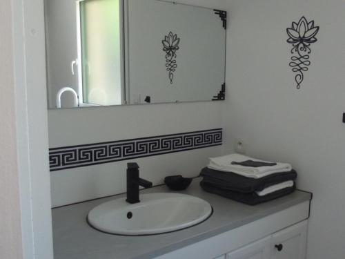 une salle de bain avec un lavabo et un miroir dans l'établissement A coté des plages et des marais salants de Guérande, à Guérande