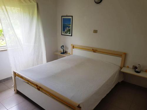 a bedroom with a white bed and a window at Residence Poseidon Villaggio in Isola Capo Rizzuto