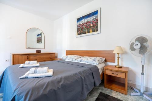 a bedroom with a large bed and a fan at Holiday Home Casa Blu near the Beach in Neum
