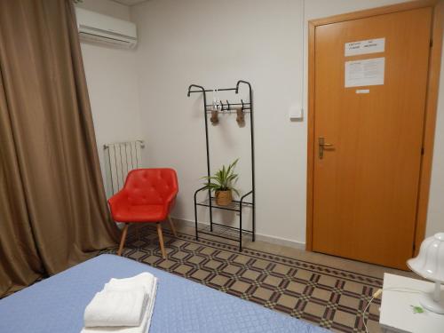 a room with a red chair and a door at In pieno centro in Crotone