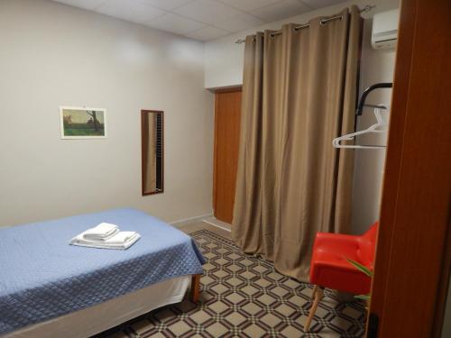 a hospital room with a bed and a red chair at In pieno centro in Crotone