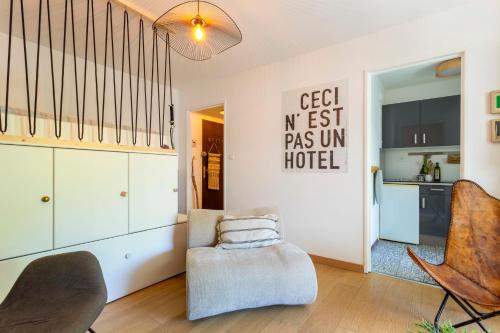 ein Wohnzimmer mit einer Treppe und einem Stuhl in der Unterkunft Chez Stéphanie De - Superbe studio design en centre ville avec piscine in La Grande-Motte