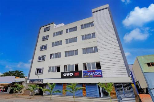 a large white building with a sign on it at Hotel O PRAMOD GUEST INN in Nellore