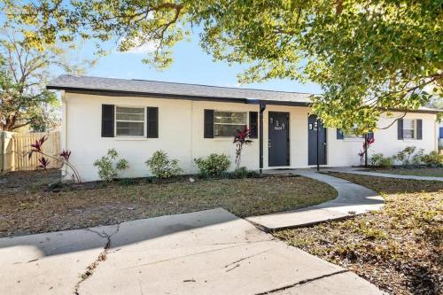 a white house with a driveway in front of it at Charming Duplex in Zephyrhills! #2 in Zephyrhills