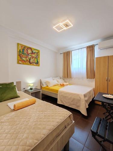 a hotel room with two beds and a table at Guest House Lara in Neum