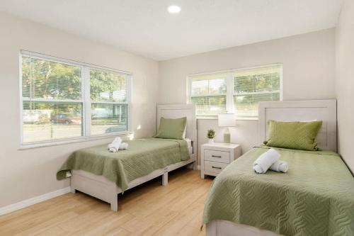 a bedroom with two beds and two windows at Spacious Duplex Zephyrhills #2 in Zephyrhills
