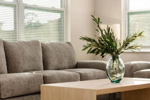 a living room with a couch and a vase on a table at Spacious Zephyrhills Duplex #1 in Zephyrhills