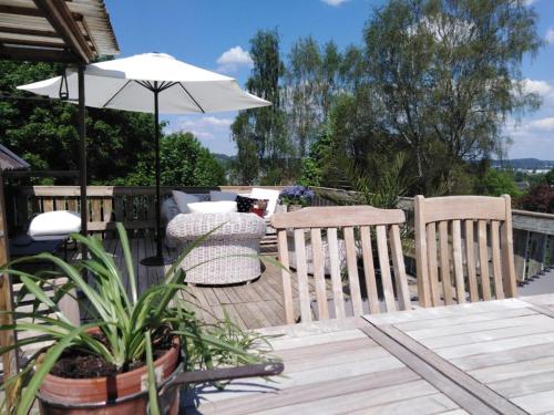 a patio with a table and chairs and an umbrella at Haby House Old in Skene