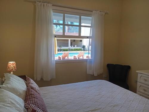una camera con letto e finestra con vista sulla piscina di Casa Região Privilegiada próx. ao Centro e Clube Campo. a Joanópolis