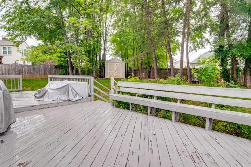 a couple of white benches on a wooden deck at Family Retreat with Fenced Yard in Woodbridge! in Woodbridge