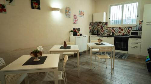 a kitchen with white tables and chairs in a room at Sirio Marsala in Birgi Vecchi