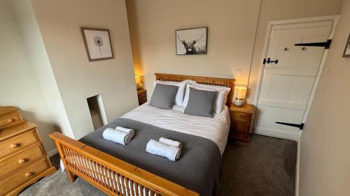 une chambre avec un lit avec des serviettes dessus dans l'établissement Wisteria Cottage, à Eyam