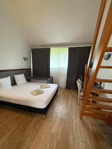 a bedroom with a large bed and a staircase at Ma Campagne in Saint-Rémy