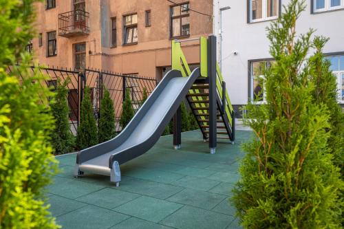 a playground with a slide in front of a building at Gatve apartment in Rīga