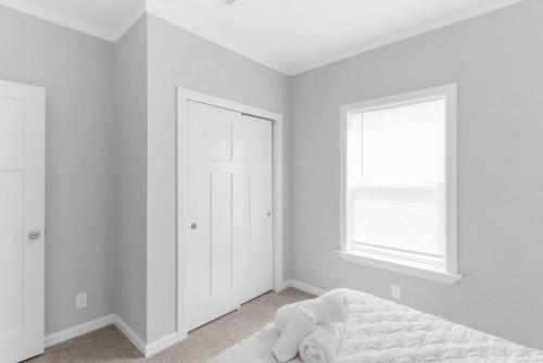 a white bedroom with a bed and a window at Comfy 2 Bedroom home, Dade City! in Dade City