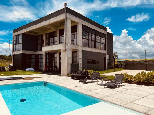 a house with a swimming pool in front of it at Casa Pillar - Casa de Alto Padrão em Ilhéus in Ilhéus