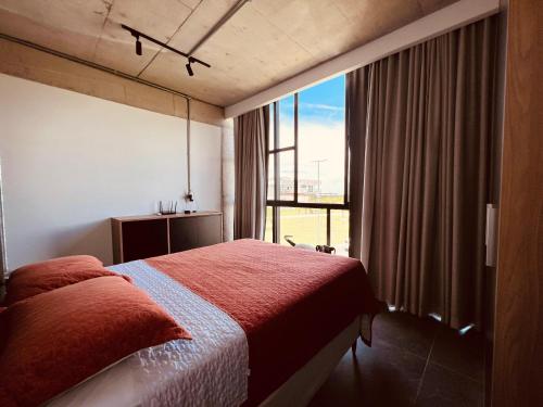 a bedroom with a bed and a large window at Casa Pillar - Casa de Alto Padrão em Ilhéus in Ilhéus