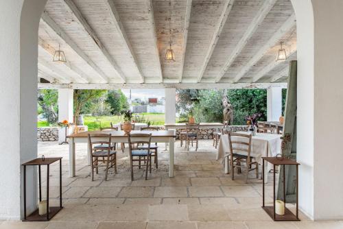an outdoor dining area with tables and chairs at L'aia di San Giorgio in Ortelle