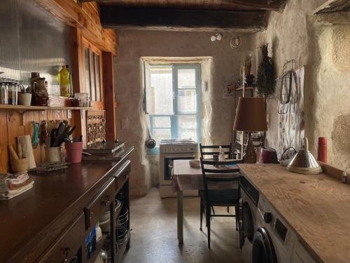 une cuisine avec un comptoir, une table et une fenêtre dans l'établissement Cocon sur jardin, à Douarnenez