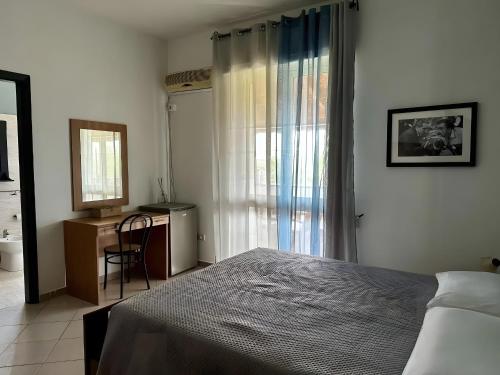 a bedroom with a bed and a desk and a window at L'aia di San Giorgio in Ortelle