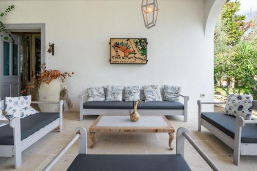 a patio with blue couches and a coffee table at L'aia di San Giorgio in Ortelle
