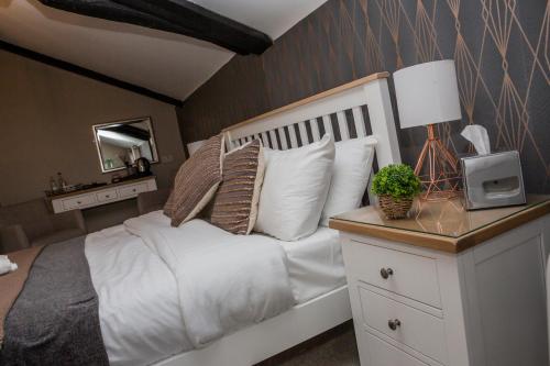 a bedroom with a large white bed with a lamp at The Black Swan Inn in Norwich