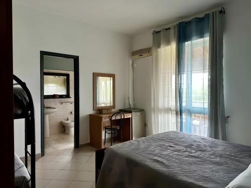 a bedroom with a bed and a bathroom with a toilet at L'aia di San Giorgio in Ortelle
