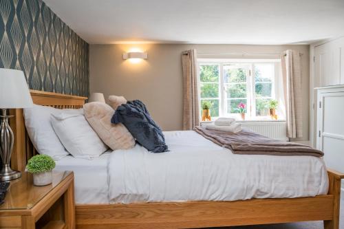 a bedroom with a large white bed with a window at The Black Swan Inn in Norwich