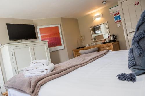 a bedroom with a bed with towels on it at The Black Swan Inn in Norwich