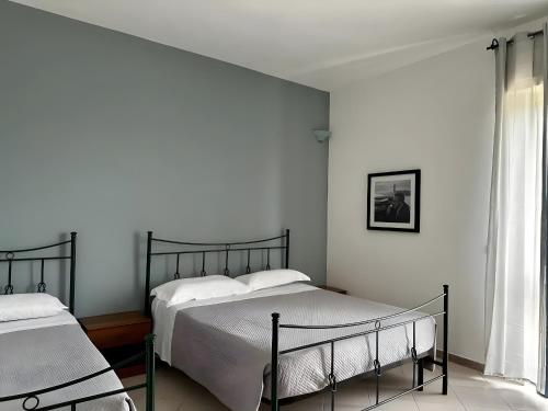 a bedroom with two beds and a window at L'aia di San Giorgio in Ortelle