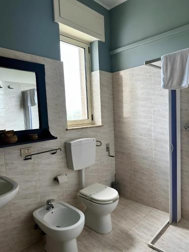 a bathroom with a toilet and a sink at L'aia di San Giorgio in Ortelle