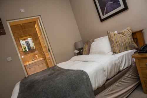 a bedroom with a bed and a dresser with a mirror at The Black Swan Inn in Norwich