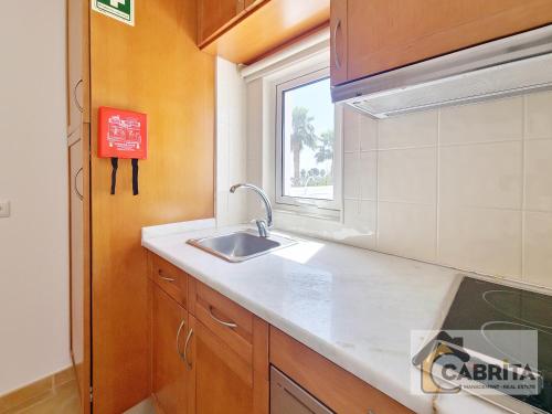 a kitchen with a sink and a window at Casa Margaret by YHA in Cabanas de Tavira