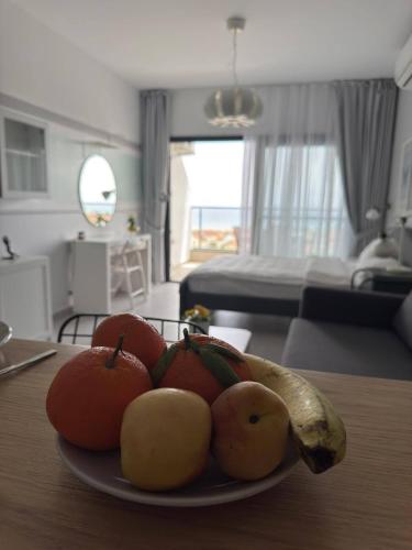 a plate of fruit on a table in a living room at Apartament Elizabeth Caesar Blue in Trikomo