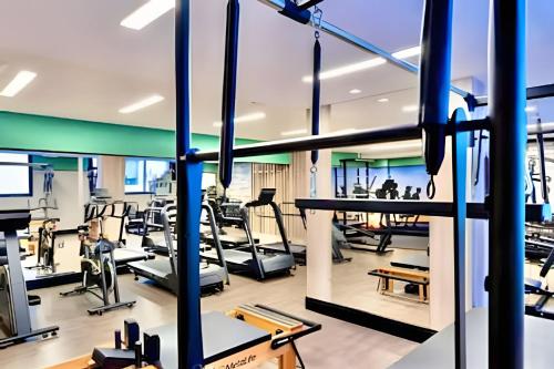 a gym with treadmills and elliptical machines at Vivendo o Melhor de Curitiba in Curitiba