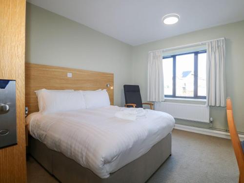 a bedroom with a large bed and a window at Pebble Path at Marine Court in Littlehampton