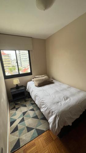 a small bedroom with a bed and a window at Habitación central Viña Centro, barrio Poniente in Viña del Mar