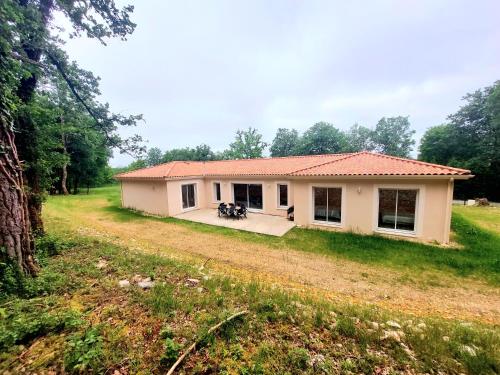 une petite maison blanche dans un champ herbeux dans l'établissement 