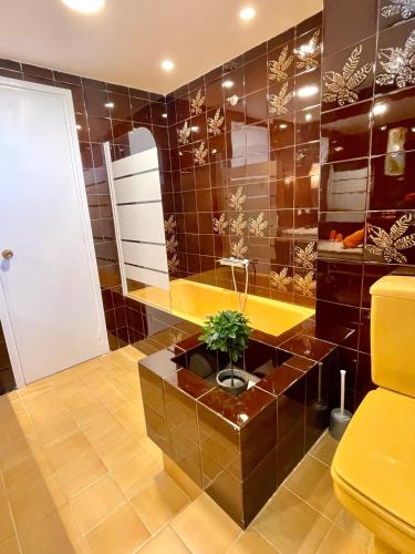 a bathroom with a brown tiled wall at MASIA EN COSTA DORADA y CLIMATIZADA in Reus