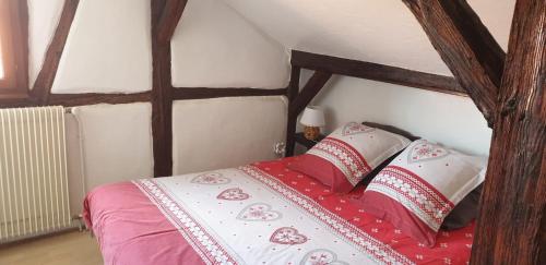 - une chambre avec un lit et une couette rouge et blanche dans l'établissement Baribal'ele, à Colmar