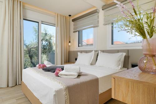 a bedroom with a large bed with a vase on it at Luxury Villa Fotini in Limenas