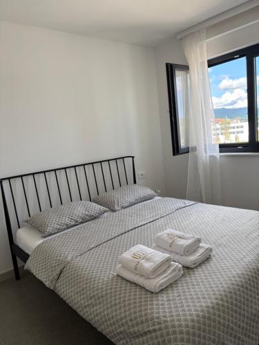 a bedroom with a bed with two towels on it at Apartment Delux in Posušje