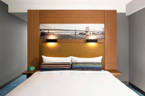 a bedroom with a large bed with a wooden headboard at Aloft New York Brooklyn in Brooklyn
