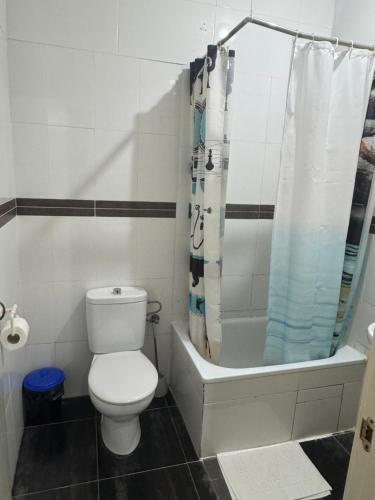 a white bathroom with a toilet and a shower at Hostal Granvia 628 in Barcelona